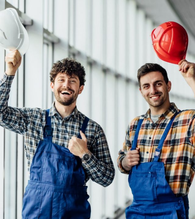 good-looking-construction-worker-sharing-with-experience-with-colleague-holding-helmet
